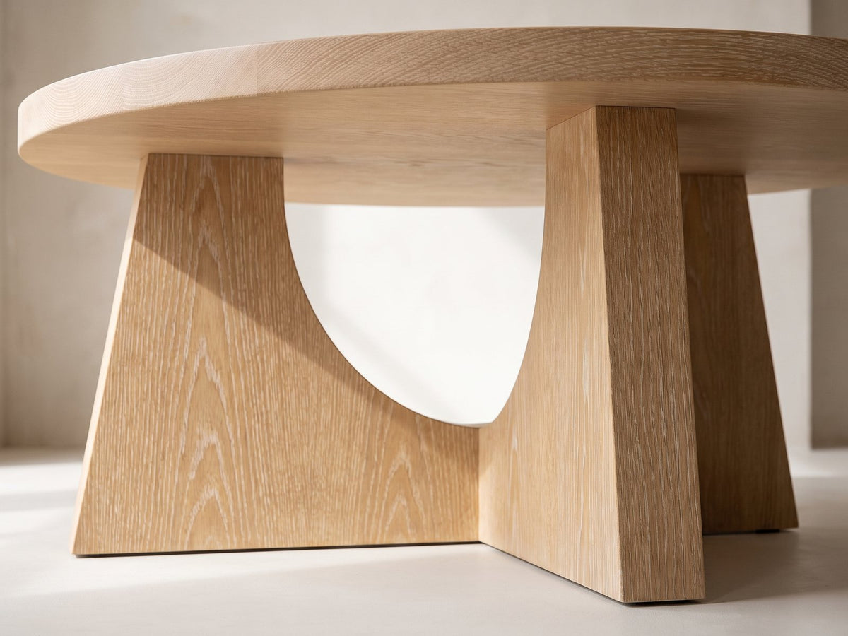 Close-up of the Fiesole Cerused Oak Veneer Round Pedestal Coffee Table: the crossed oak panels of the base under the round top