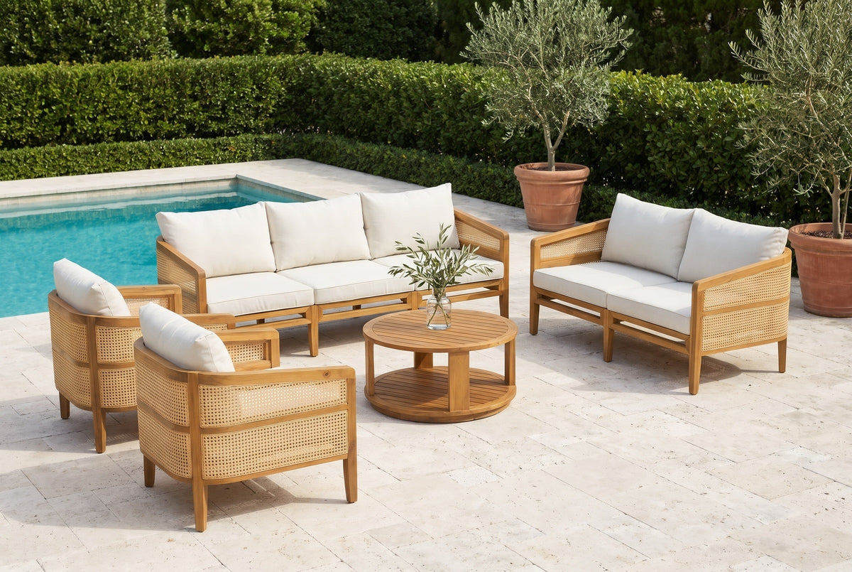 Filicudi acacia and rattan set on a limestone pool terrace at a Palm Beach villa, a clipped hedge and potted olive trees behind (vase and olive stems not included)