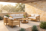 Filicudi five-piece acacia and rattan set on a limestone terrace in the Texas Hill Country at golden hour, a cedar pergola and live oaks behind (vase and plants not included)