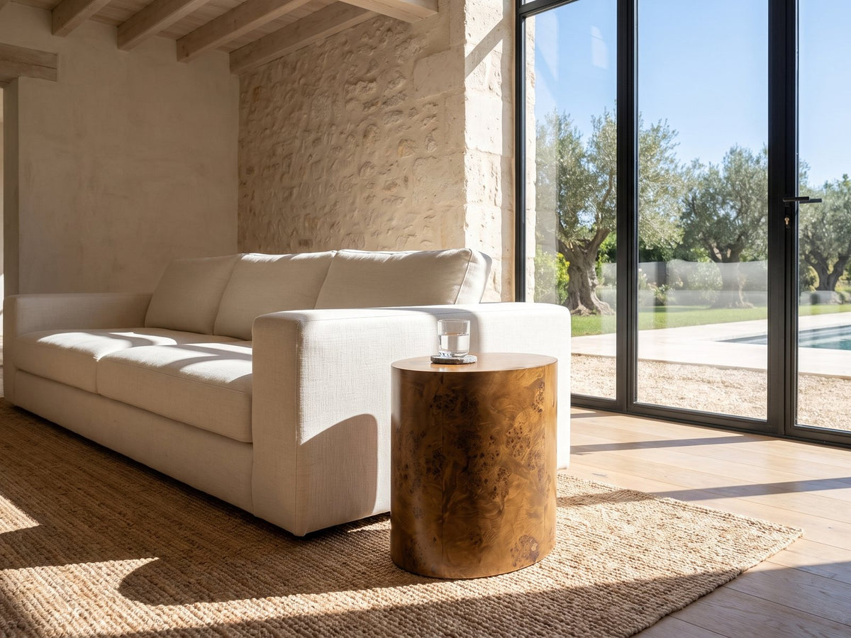 Fiumefreddo Walnut Burl Oval Pillar Side Table beside a linen sofa in a poolside villa