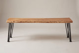 The Foligno bench in natural acacia, long side view on a light studio backdrop