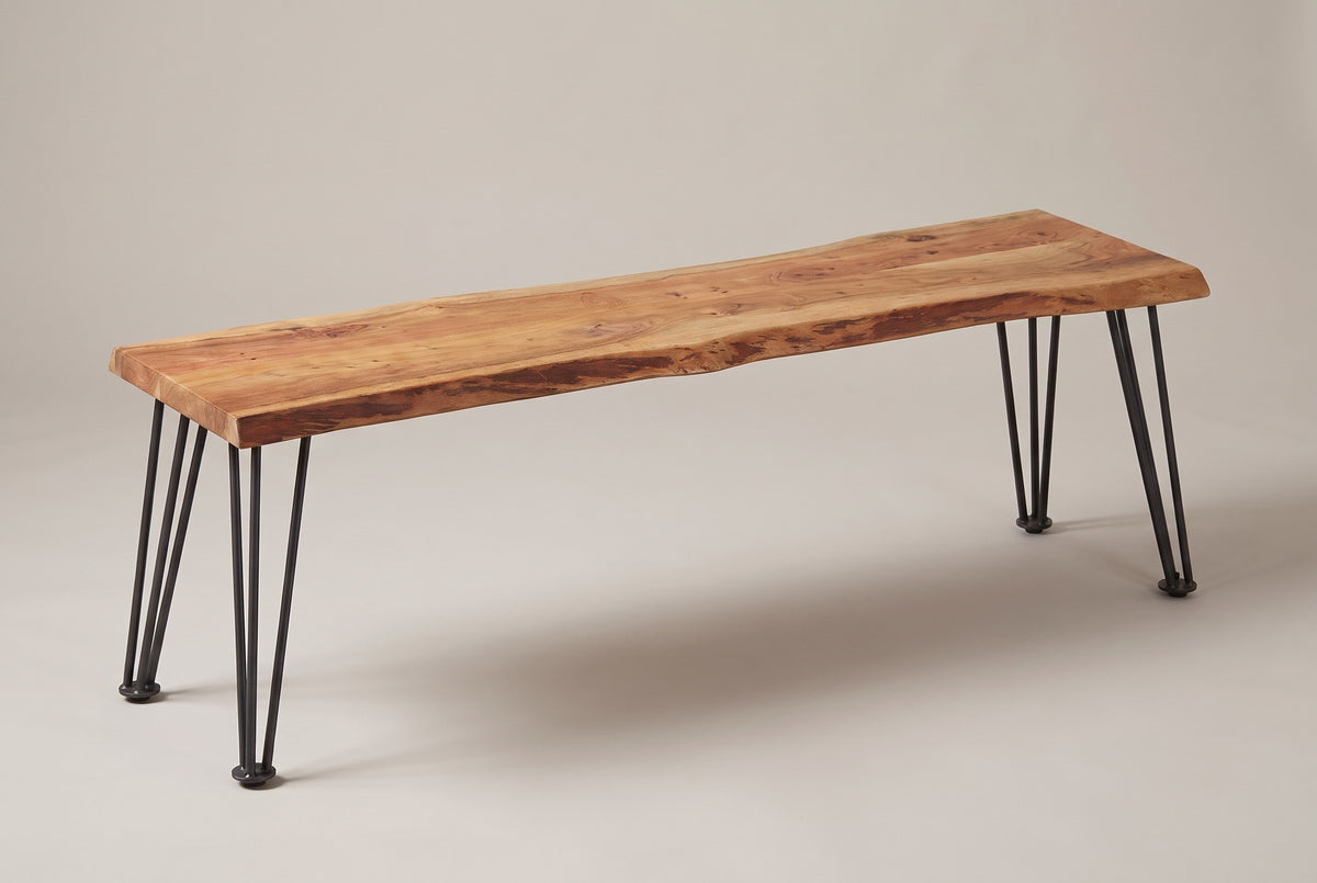 The Foligno bench in natural acacia, three-quarter view on a light studio backdrop