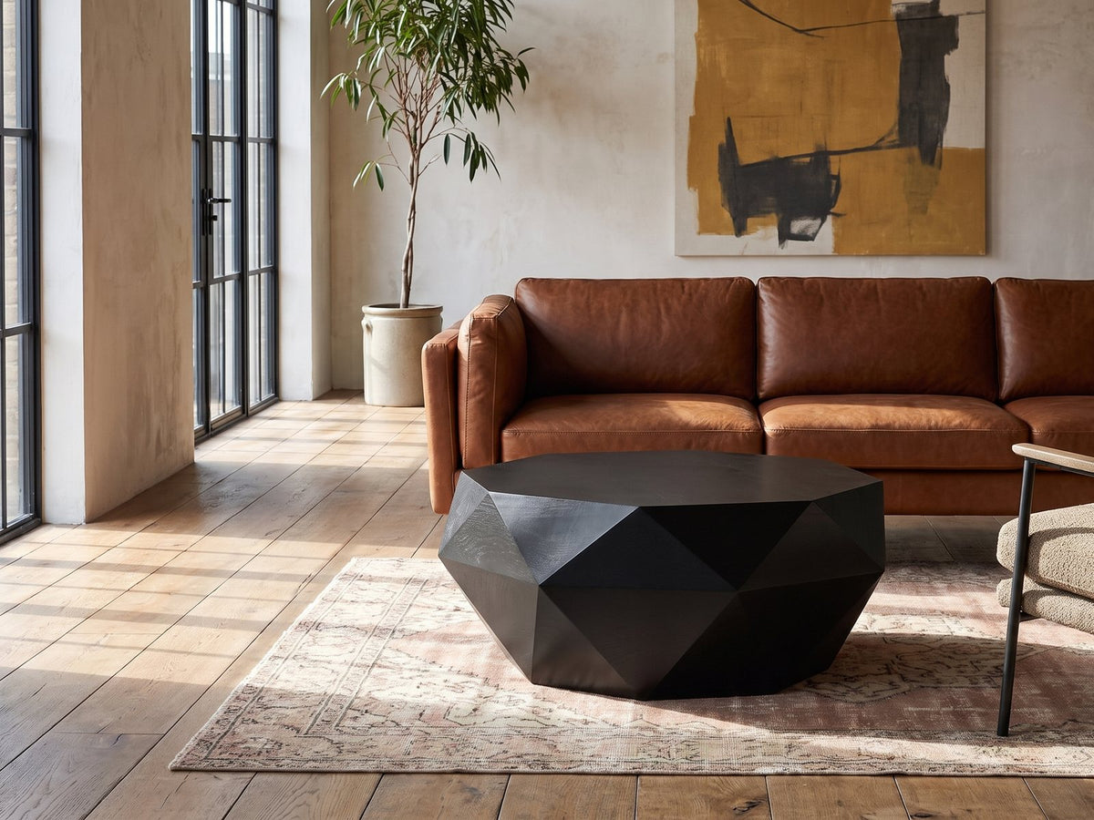 Follonica Faceted Acacia Coffee Table on a vintage rug in front of a leather sofa in an industrial loft