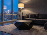 Follonica Faceted Acacia Coffee Table on a wool rug in front of a velvet sofa in a city penthouse at blue hour