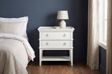 Fonni white tray-top nightstand with a ceramic lamp against a deep navy wall in a Charleston townhouse bedroom with a walnut floor and linen curtains