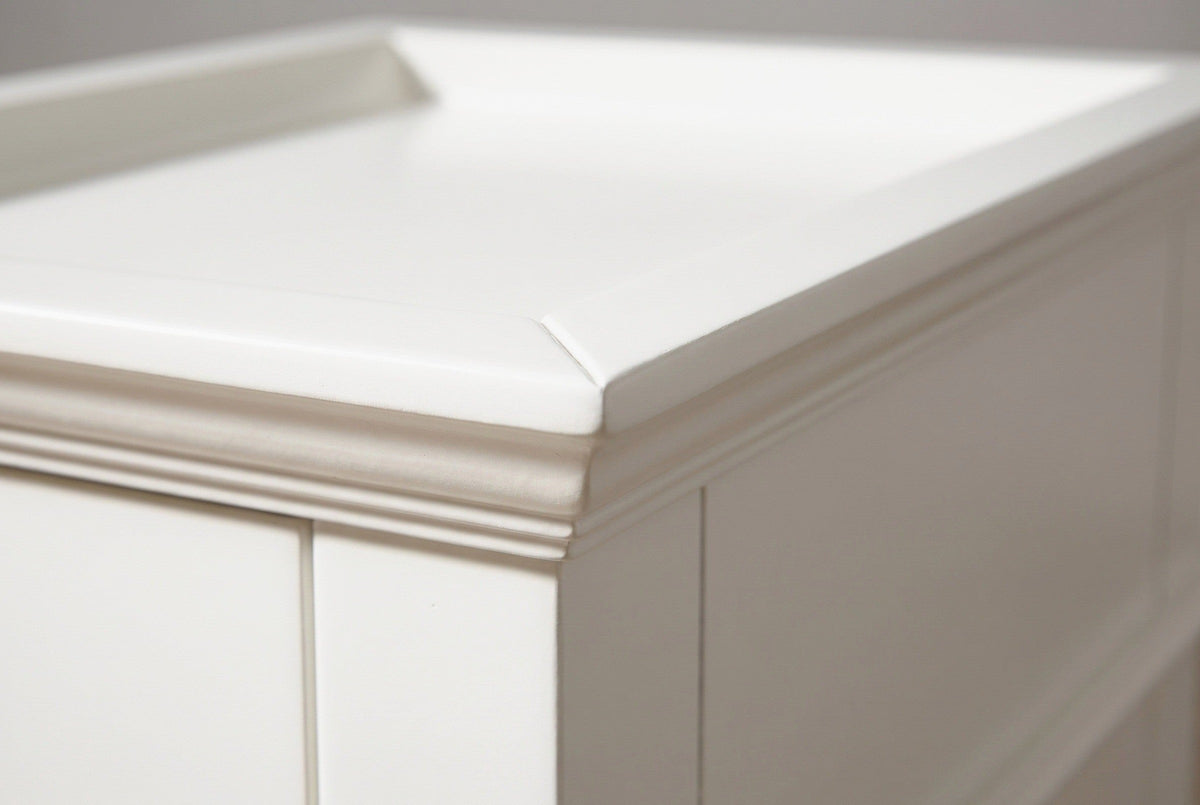 Close-up of the raised lip and the stepped cove moulding at the corner of the white tray top of the Fonni nightstand