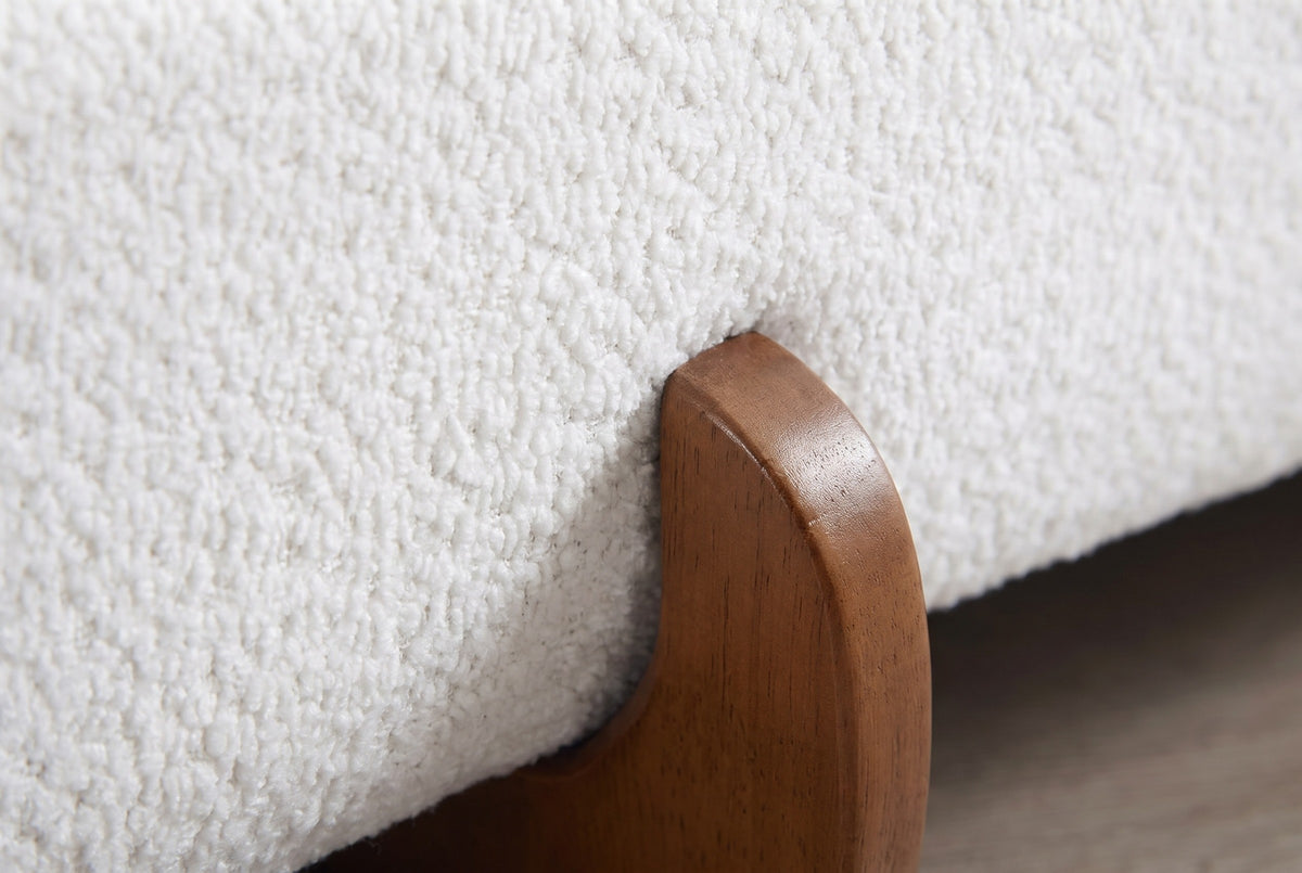 Close-up of the Fossacesia bed where the white textured fabric of the rail meets a walnut-tone rubberwood foot