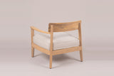 A Furnari club chair from behind: the curved acacia back panel on two square posts, the beige seat cushion and an arm sweeping forward