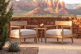 Two Furnari acacia club chairs on a flagstone patio in Sedona at golden hour, a red sandstone wall and red rock buttes behind (side table not included)