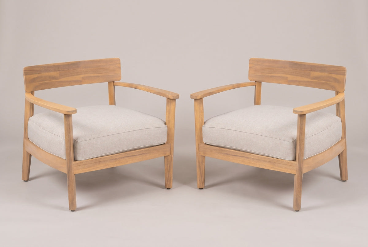 The Furnari set of two acacia club chairs with beige seat cushions, three-quarter view on a light studio backdrop
