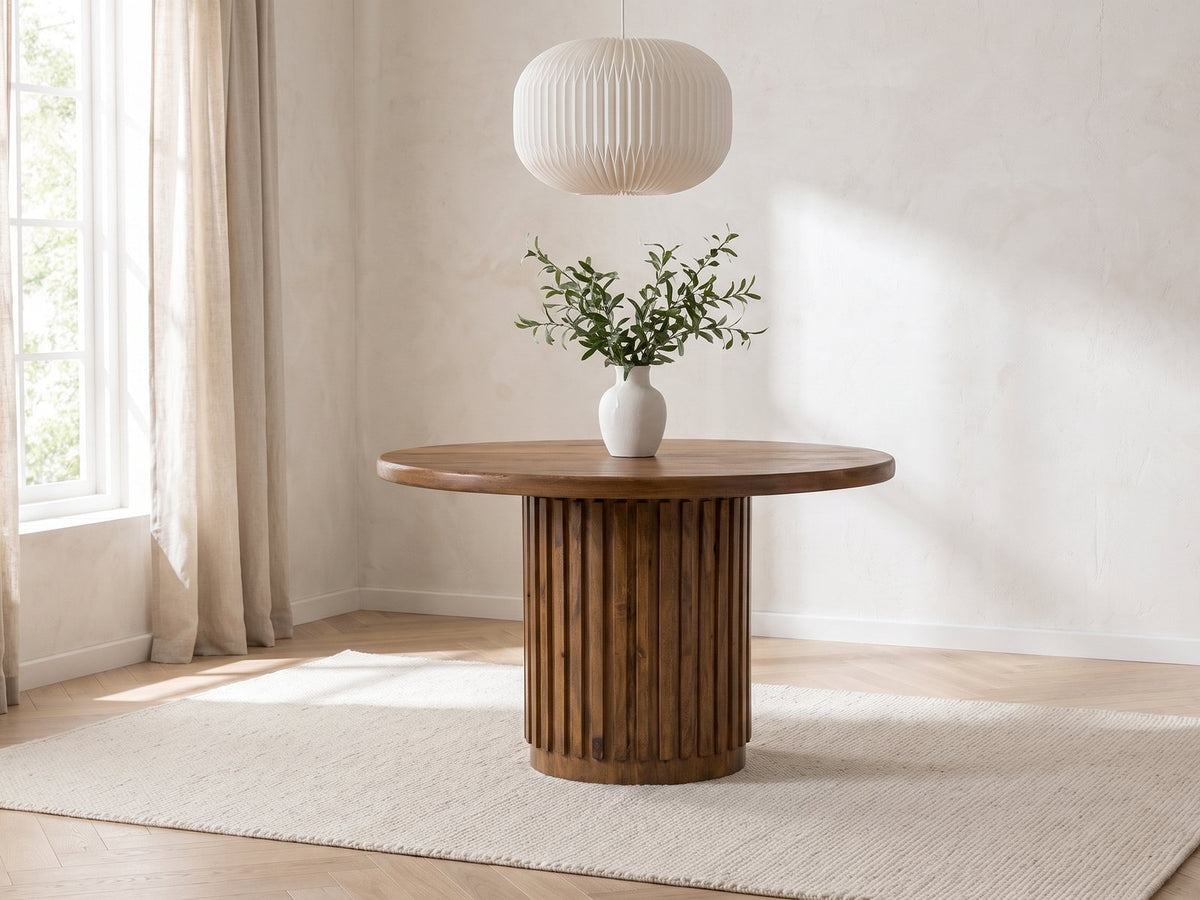 Fuscaldo 47-Inch Round Mango Wood Slatted Pedestal Dining Table in a bright plaster dining room with linen curtains
