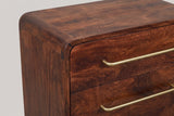 The top front corner of the Galtelli nightstand: the top rolling over a rounded corner of curved mango blocks, with the long brass bar pulls on the flush drawer fronts
