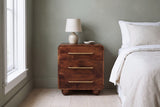 Galtelli chestnut mango nightstand against a muted sage green plaster wall in a Portland bedroom with a white window and pale ash floors