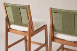 The Ganzirri stools from behind: the sage-green woven backs, the leaning back posts bolted to the rear legs and the ivory cushions