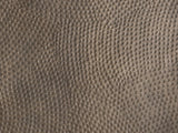 Close-up of the Gavi 32-Inch Round Antique Bronze Faceted Aluminum Drum Coffee Table: the hand-hammered top in antique bronze