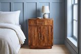 Gavoi fluted mango bow-front nightstand with a ceramic lamp in a Charleston bedroom with a blue-grey board-and-batten wall and pale heart-pine floors