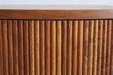 Close-up of the reeded mocha mango wood on the Gavoi nightstand: vertical rounded reeds below the plain mango top