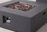 Close-up of the Gela fire pit: the flat dark gray concrete frame with its fine pores, the stepped edge of the square pan, lava rocks and the ring burner