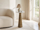 Genazzano White Marble Tapered Pedestal Side Table with a lamp and a ceramic bowl beside a cream boucle armchair in a bright plaster room