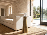 Genazzano White Marble Tapered Pedestal Side Table beside a linen sofa in a poolside villa