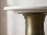 Close-up of the Genazzano White Marble Tapered Pedestal Side Table: the rounded marble edge over the brushed antique brass flare