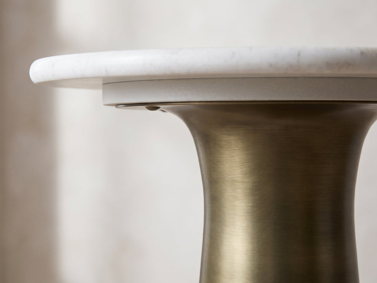 Close-up of the Genazzano White Marble Tapered Pedestal Side Table: the rounded marble edge over the brushed antique brass flare