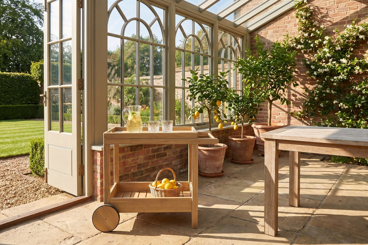 Gerocarne 36-Inch Acacia Wood Outdoor Rolling Bar Cart in an orangery