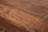 Close-up of the chestnut mango wood on the Ghilarza nightstand: reddish brown grain with darker streaks running to a rounded edge
