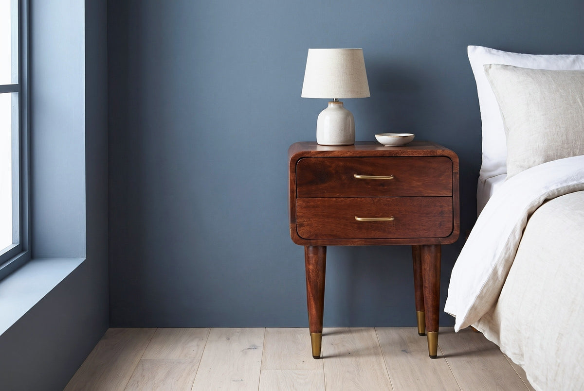 Ghilarza chestnut mango nightstand against a deep slate blue plaster wall in a Minneapolis bedroom with pale oak floorboards