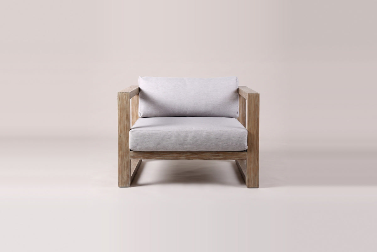 The Giardini lounge chair from the front: two side frames standing on their runners, the front seat rail and the gray seat and back cushions