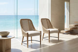 Gioiosa Cane-Back Upholstered Wood Dining Chair (Set of 2) in an oceanfront glass house