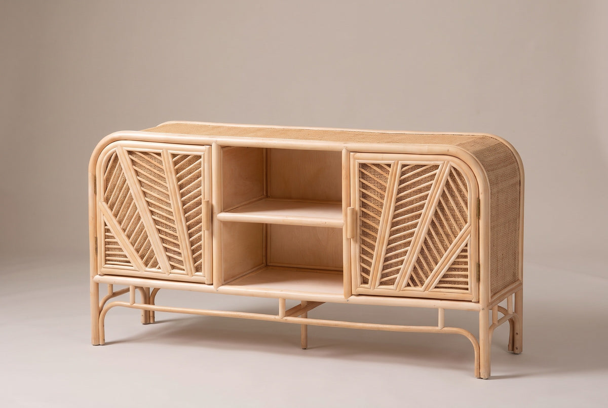 The Giovinazzo rattan and cane sideboard, three-quarter view on a light studio backdrop: two palm-leaf doors, an open centre bay and an open pole base