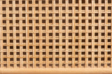 Close-up of the woven cane on the Giovinazzo sideboard: flat natural strands woven over and under in an open square mesh, with a round rattan pole along the bottom edge
