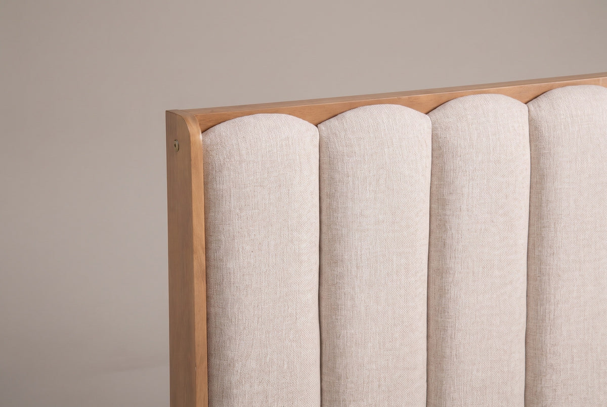 The upper left of the Giulianova headboard: four padded oatmeal channels with rounded arches inside the slim pine frame