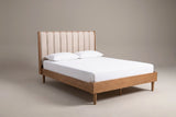 The Giulianova bed in wheat pine with an oatmeal scalloped headboard, a white mattress and pillows (not included), three-quarter view on a light studio backdrop