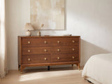 Gorizia 62-Inch Warm Walnut 6-Drawer Dresser against a plaster wall under an abstract canvas in a bright bedroom