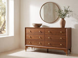 Gorizia 62-Inch Warm Walnut 6-Drawer Dresser under a round bronze mirror in a villa bedroom