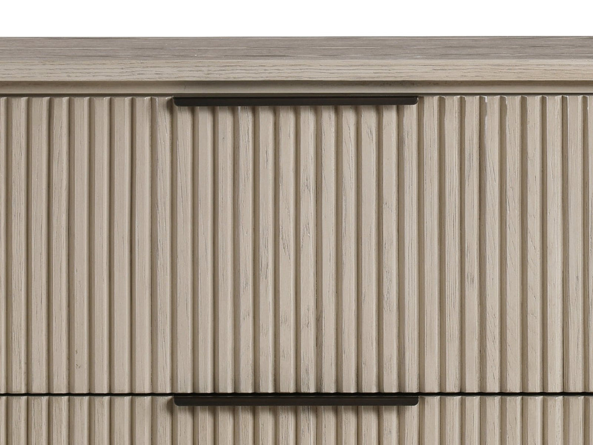 Close-up of the Gradisca 50-Inch Light Oak 4-Drawer Chest: the slim bronze edge pull on a reeded oak drawer front under the oval top