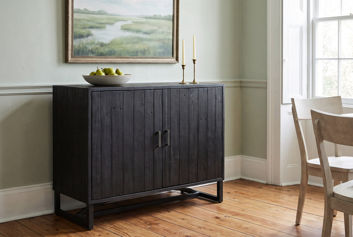 Gravina black reclaimed pine cabinet in a Charleston dining room with a pale sage wall, heart-pine floor, a bowl of pears and two candlesticks on top