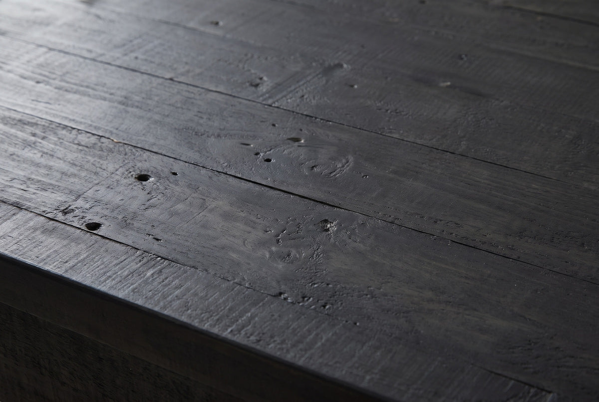 Close-up of black-stained reclaimed pine on the Gravina cabinet: grain, small nail holes and saw marks running to a square edge