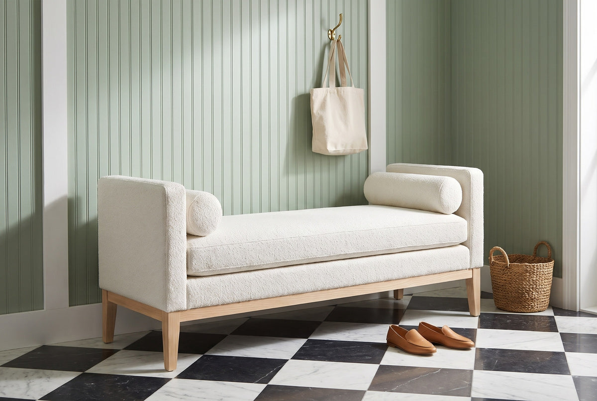 Gualdo ivory boucle bench against sage-green beadboard panelling in a Charleston entry hall with a black-and-white marble floor, a seagrass basket and a pair of loafers
