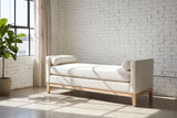 Gualdo ivory boucle bench against a white-painted brick wall in a sunny Los Angeles loft with a polished concrete floor, a black steel window and a potted fiddle-leaf fig