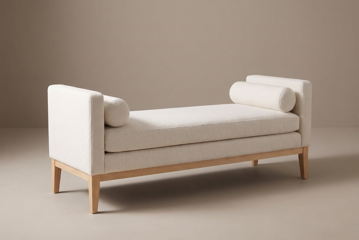The Gualdo bench in ivory boucle, three-quarter view on a light studio backdrop, with a bolster at each end