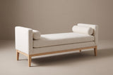 The Gualdo bench in ivory boucle, three-quarter view on a light studio backdrop, with a bolster at each end
