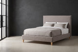 Guardiagrele taupe gray boucle bed against a charcoal limewash wall in a Chicago loft, a tall black steel window at the left