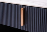 Close-up of the Guspini nightstand: the reeded charcoal drawer front, a gold-tone bar pull and the white stone top above it