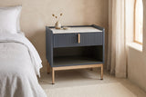 Guspini charcoal fluted nightstand against a sand Roman clay wall in a Scottsdale bedroom with a pale concrete floor and an arched window