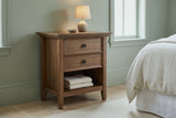Iglesias rustic brown nightstand against a sage green plaster wall in a Savannah townhouse bedroom with pale oak floorboards