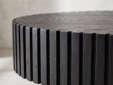 Close-up of the Imola Black Ash Oval Pedestal Coffee Table: the vertical black ash slats around the rim of the oval top