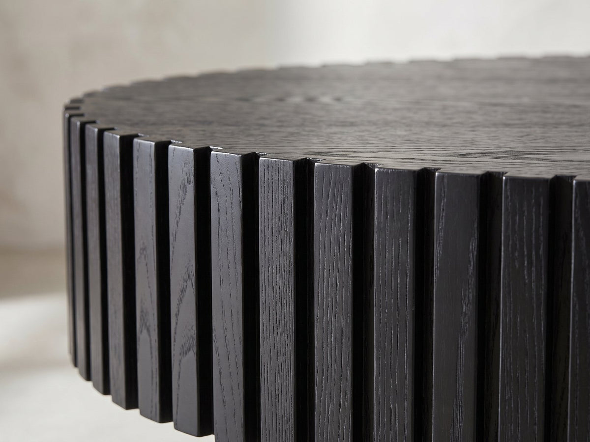 Close-up of the Imola Black Ash Oval Pedestal Coffee Table: the vertical black ash slats around the rim of the oval top